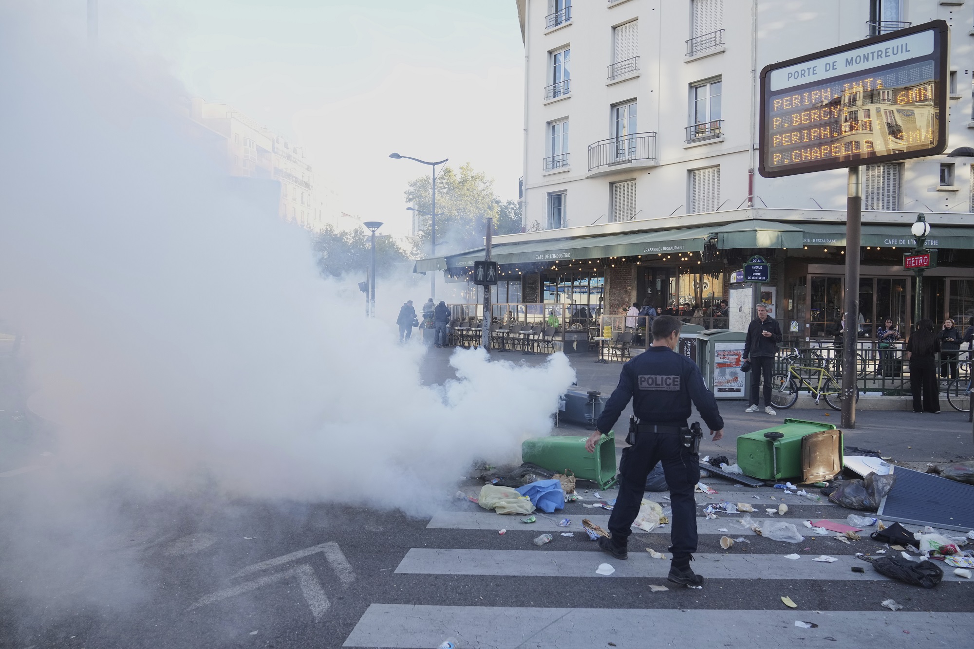 A police officer stands next to bins placed on a street to block it during the "Bloquons Tout" (Block Everything) protest movement in Paris, Wednesday, Sept. 10, 2025. (AP Photo/Thibault Camus)